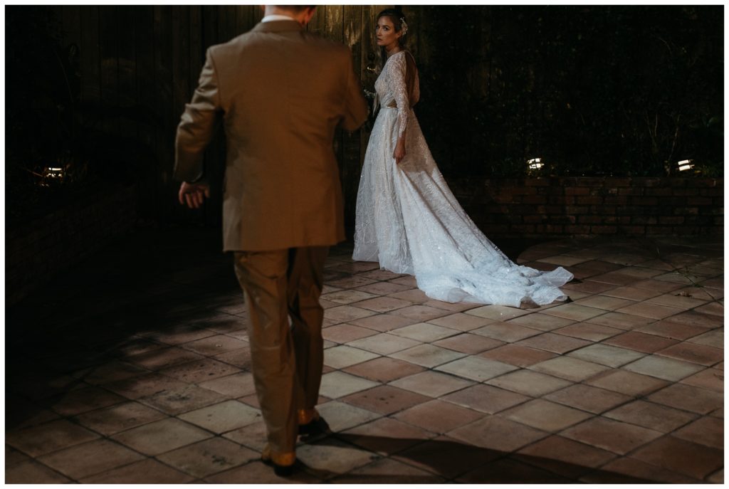 The bride and groom walk at night in the Rosy's Jazz Hall atrium