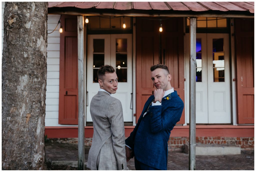 The grooms pose outside their reception at the Tigermen Den wedding