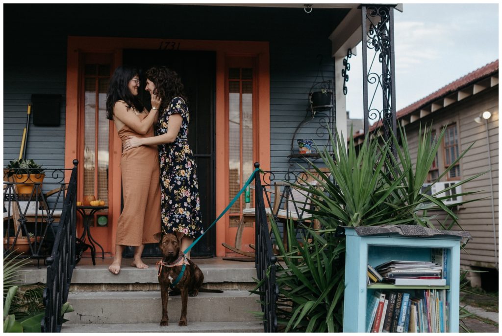 Megan and Hannah stand on their porch in their New Orleans engagement photos