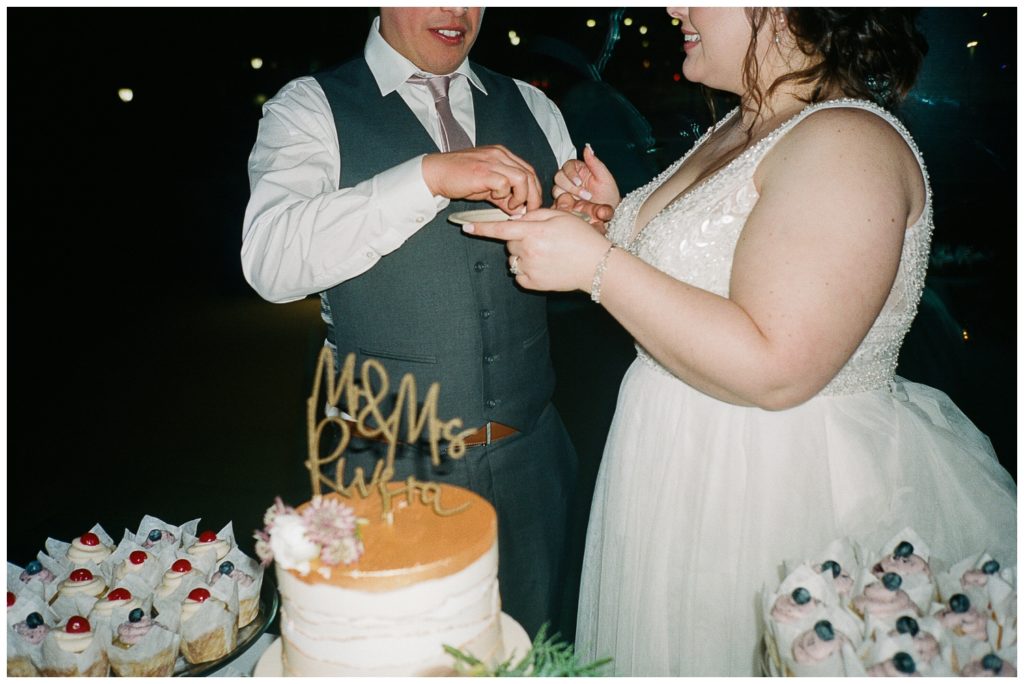 a close up of the cake in the couple's hands