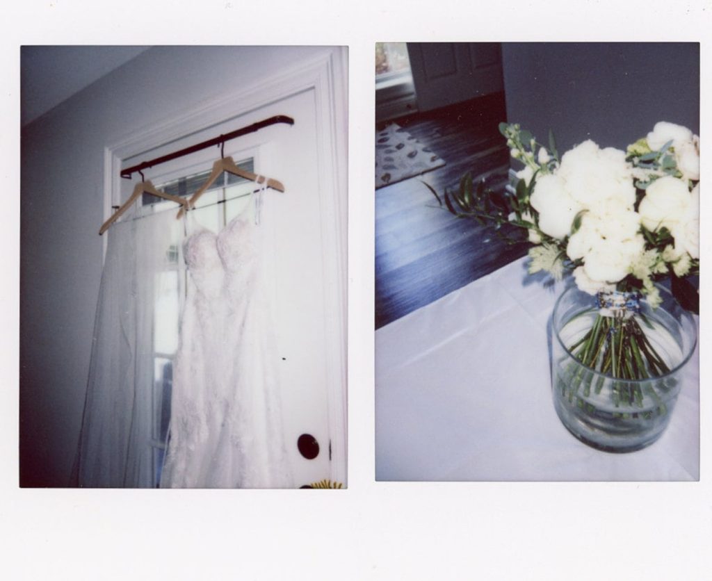 A wedding dress hangs in a window.