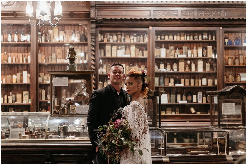 A couple stands in front of a counter at the Pharmacy Museum
