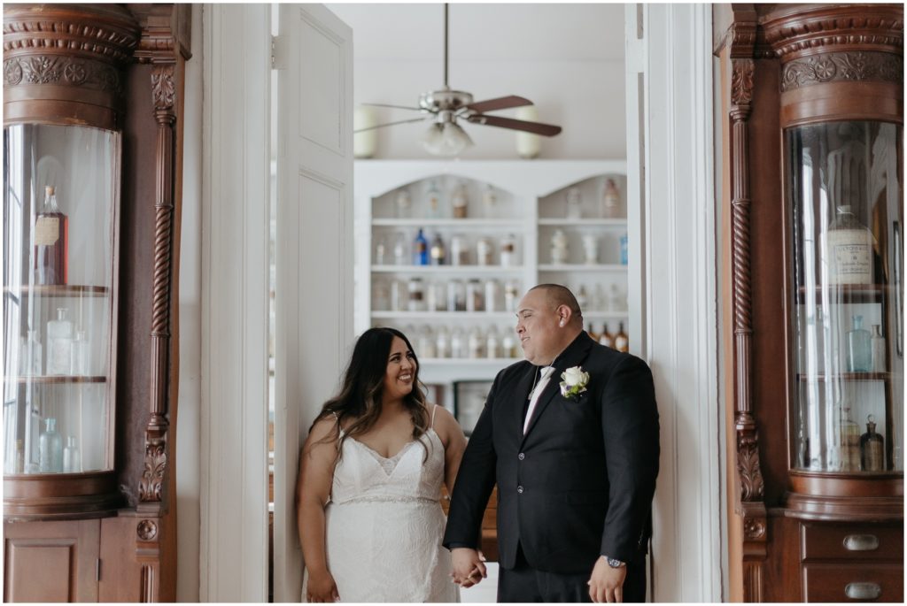 A bride and groom stand in the doorway at their Pharmacy Museum micro wedding.