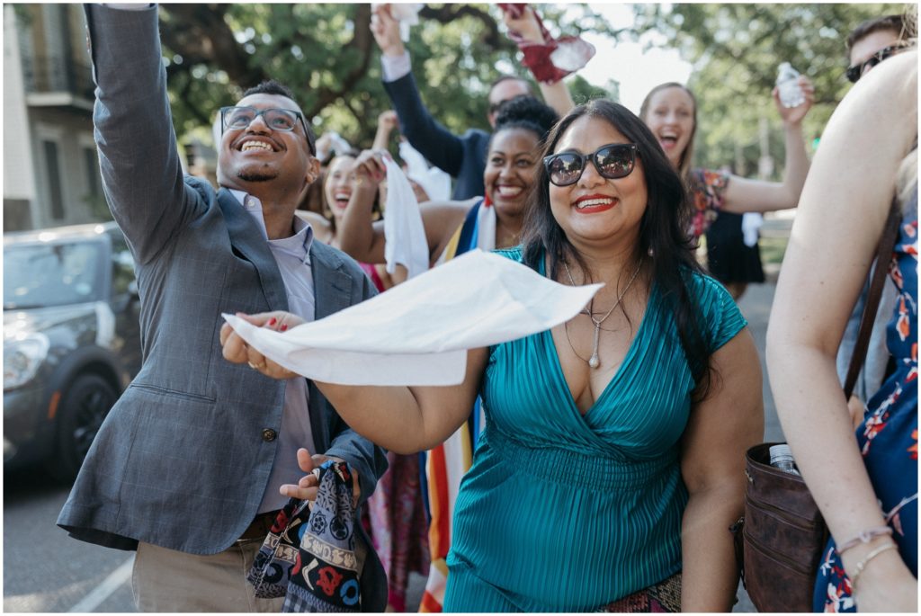 Wedding guests dance during a second line with handkerchiefs.