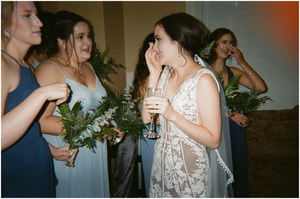 Marissa wipes away a tear while she talks to friends at her rainy wedding reception.