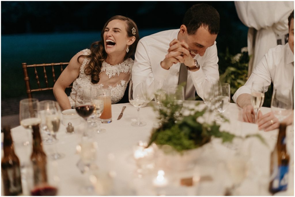 The couple laughs during a toast.
