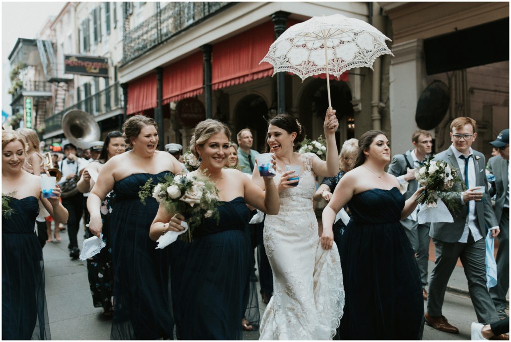 A bride raises a lace wedding umbrella.