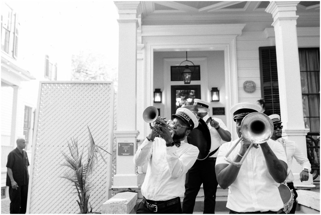 A brass band plays from a white porch.