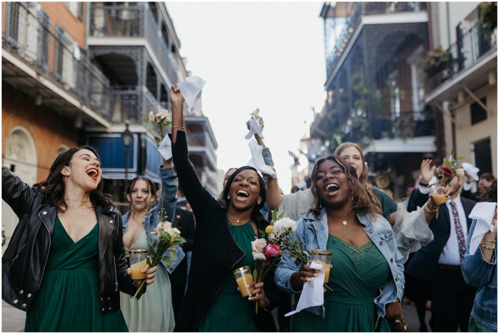Bridesmaids wave handkerchief at a New Orleans second line.