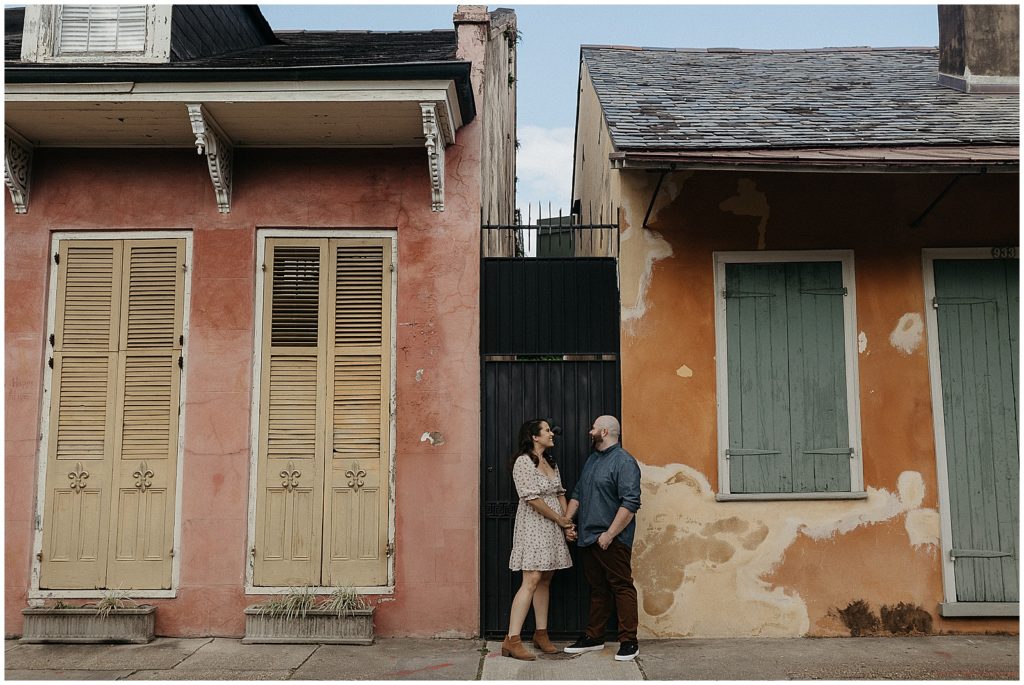 A couple walks between French Quarter houses after their New Orleans proposal.
