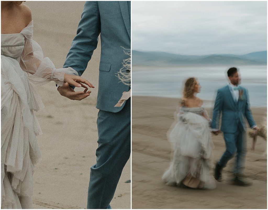 A man and woman in blue wedding attire hold hands on an Oregon beach.
