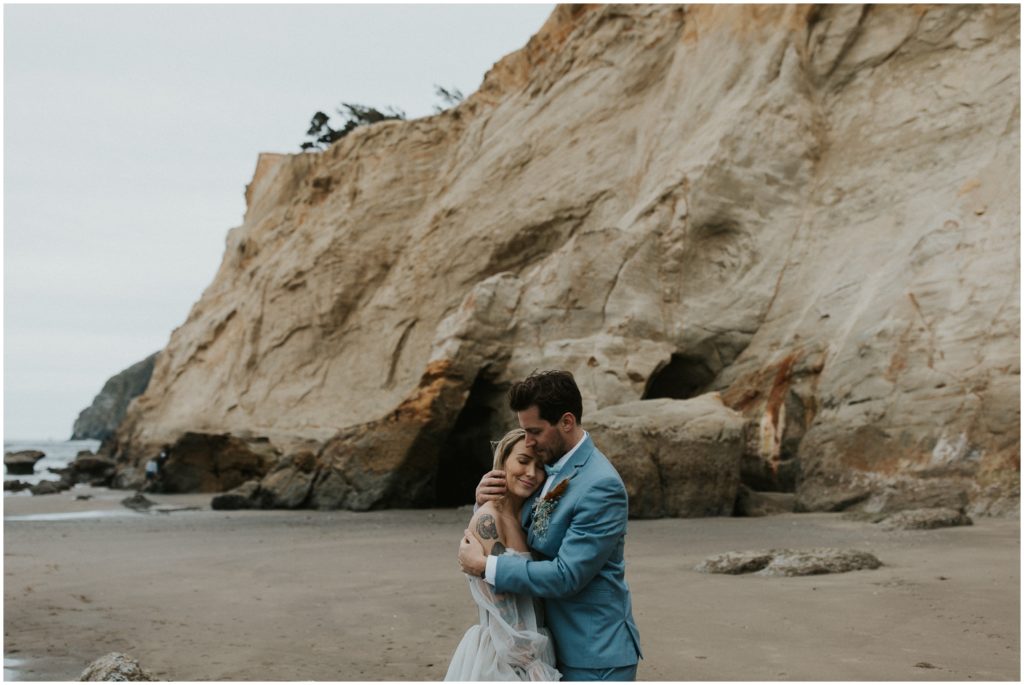 A couple embraces during their Oregon Coast elopement photo session.
