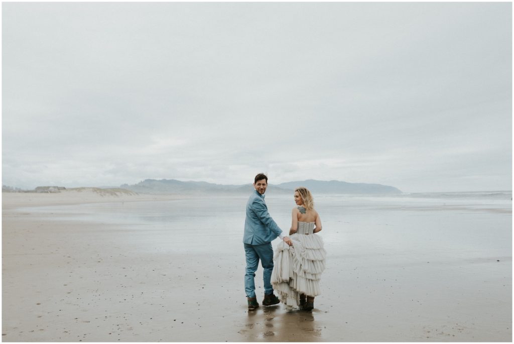 Steve and Holly look over their shoulders at their Cape Kiwanda elopement.