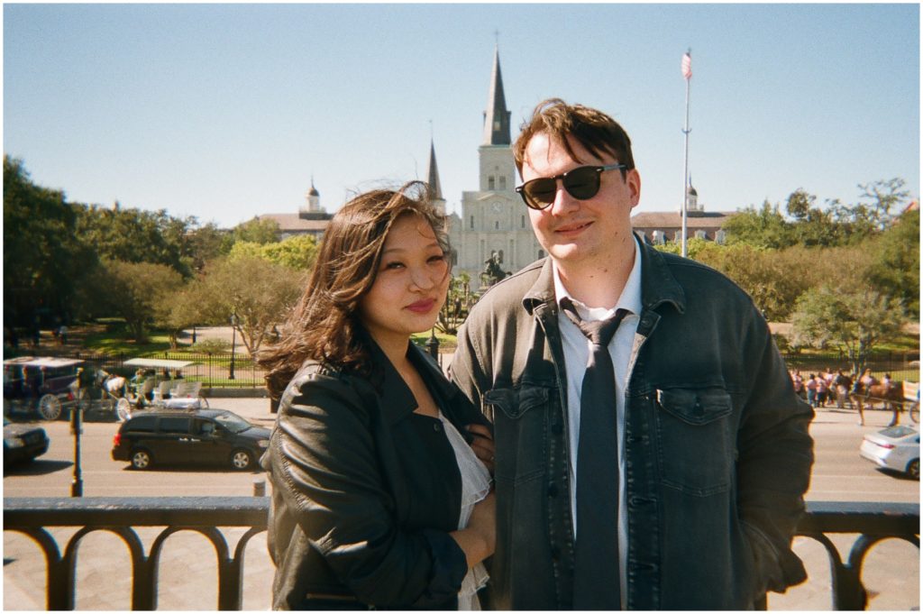 A newly wed couple stands with the St. Louis Cathedral in the background.