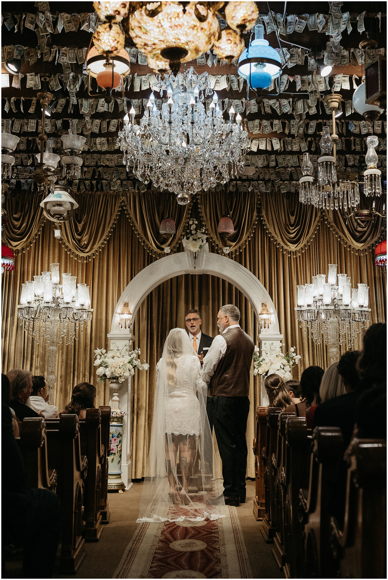 A couple stands under a white arch at the French Quarter Wedding Chapel.