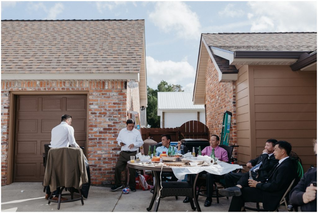 Men put food on a table in a backyard.