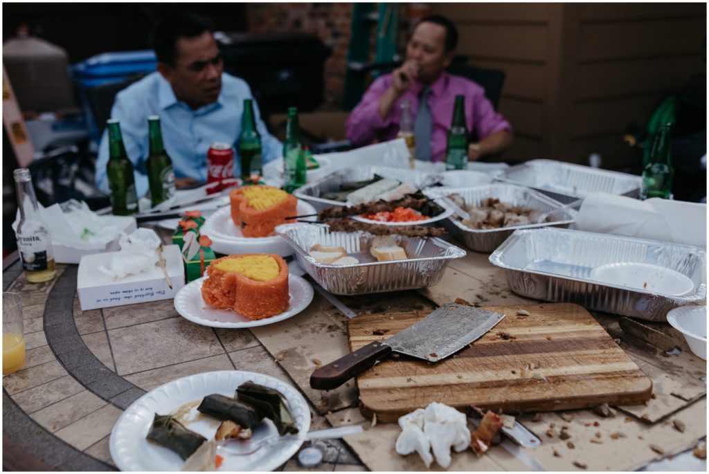 Men sit around a table with the remains of a meal on it.