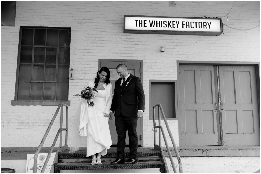 A bride and groom stand in front of their Detroit wedding venue.