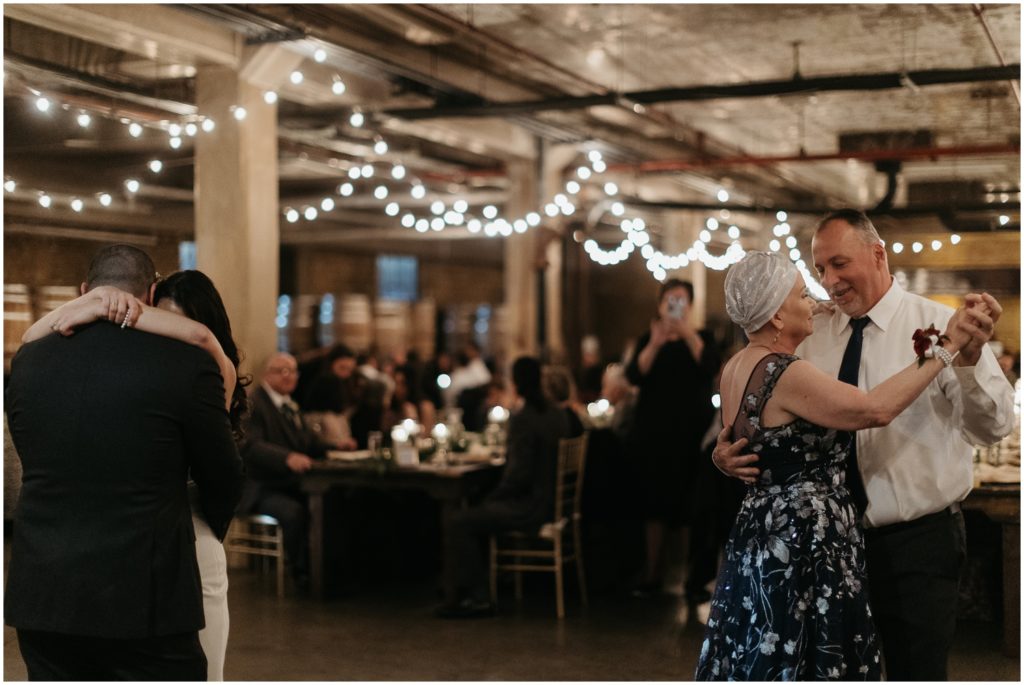 Two couples dance at a wedding reception.