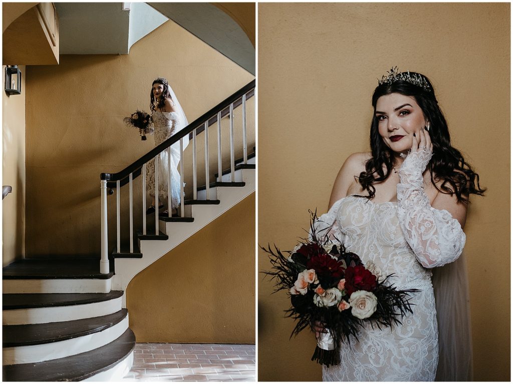A bride with gothic wedding details poses in front of a yellow wall.