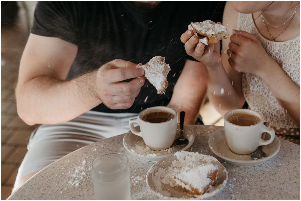 Eric dips a beignet in his coffee cup.