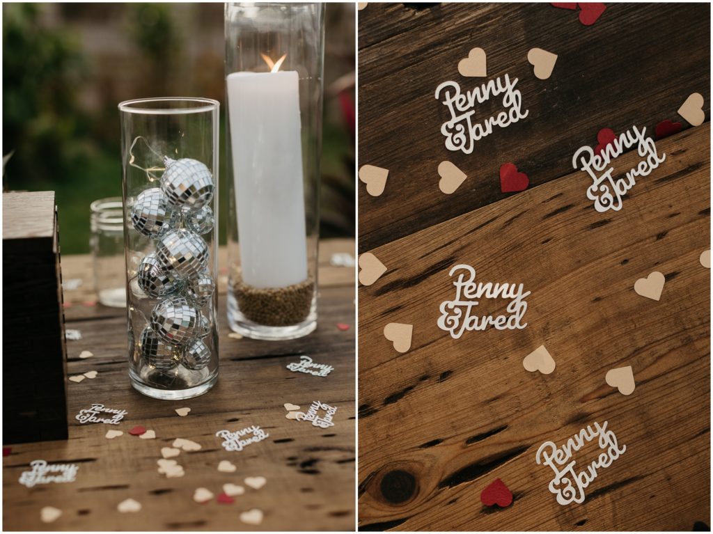 Custom wedding confetti decorates a reception table alongside candles.