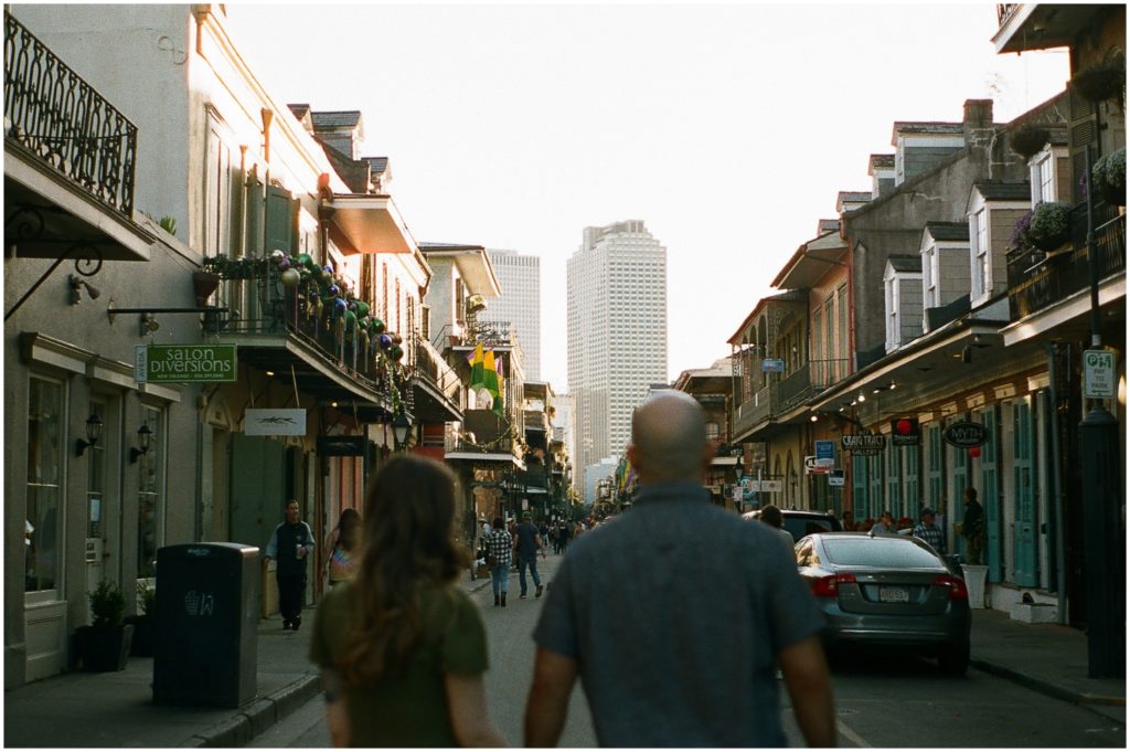 Omar and Anastasia walk down a French Quarter street at sunset.