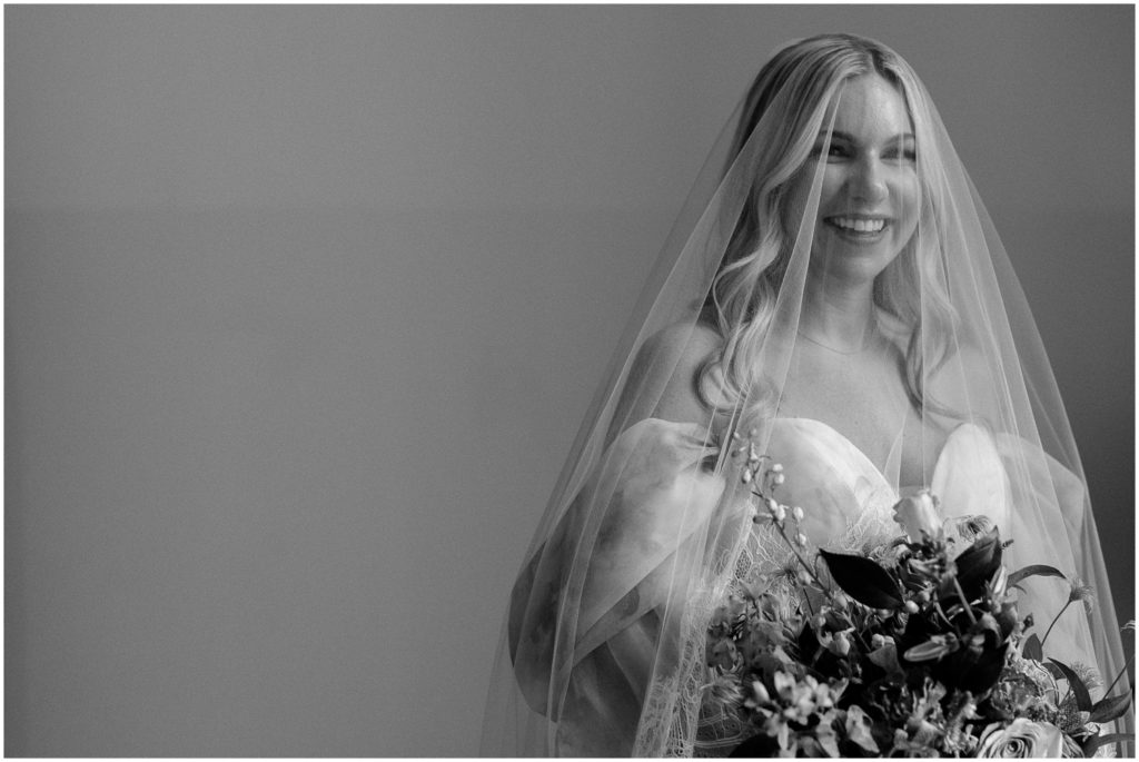 A bride smiles through her veil.