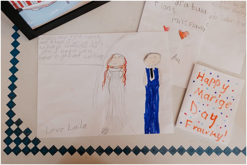 Children's drawings show Erin and James in wedding clothes.