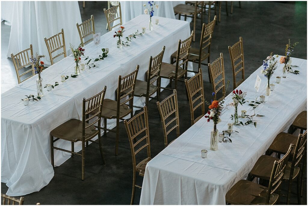Long tables are lined with flowers for a Capulet New Orleans wedding reception