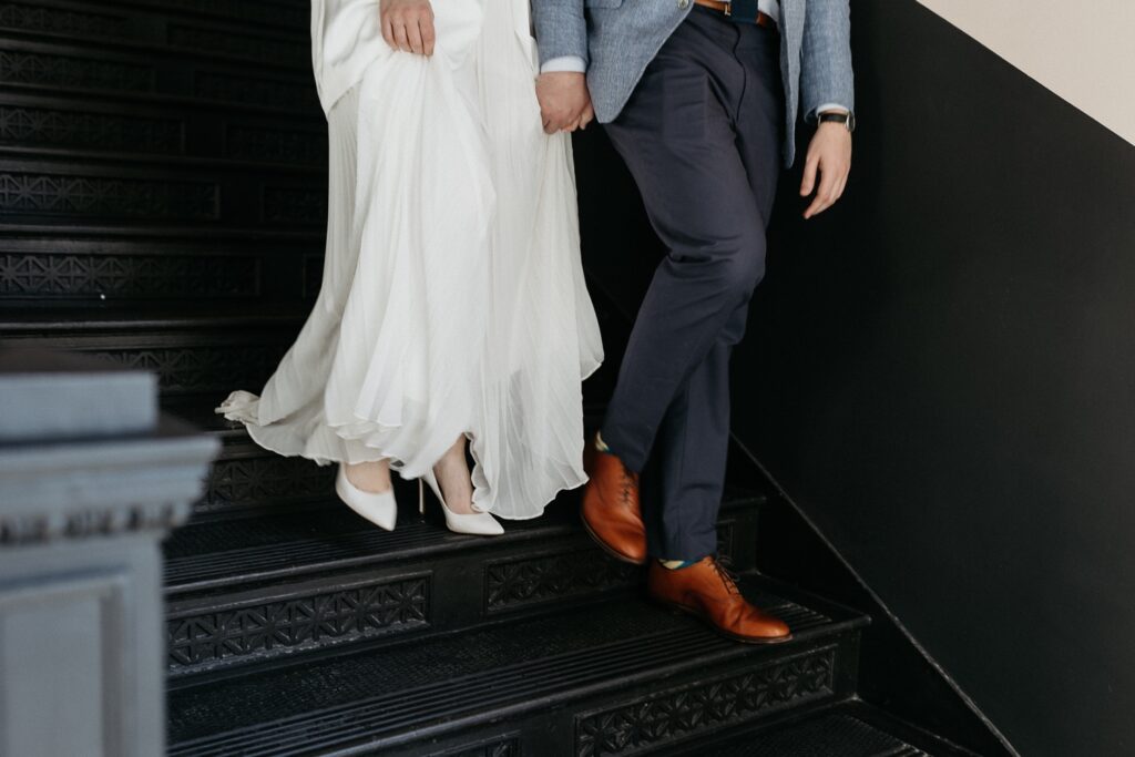 bride and groom walk down staircase at Maison de la Luz in New orleans
