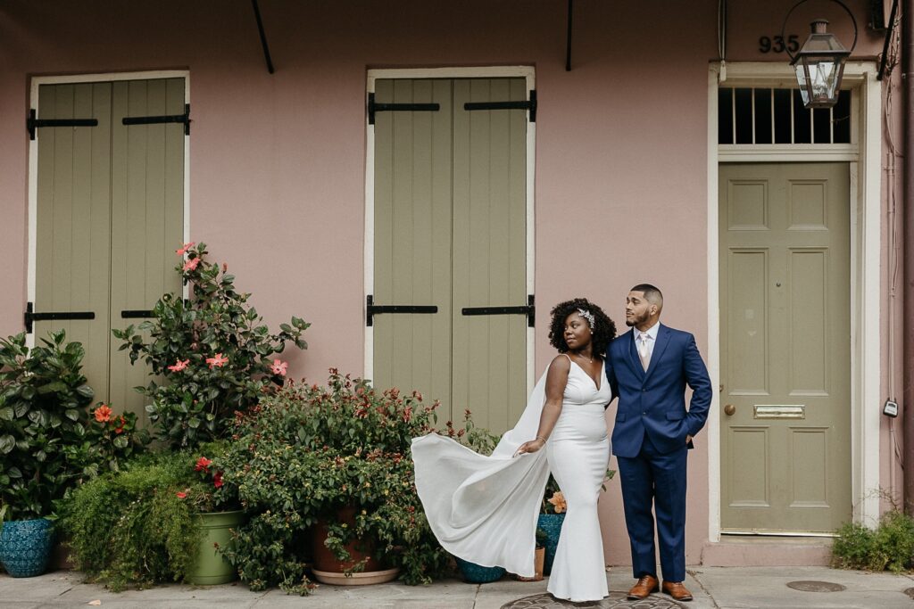 bride and groom wedding photo in french quarter in front of colorful building 