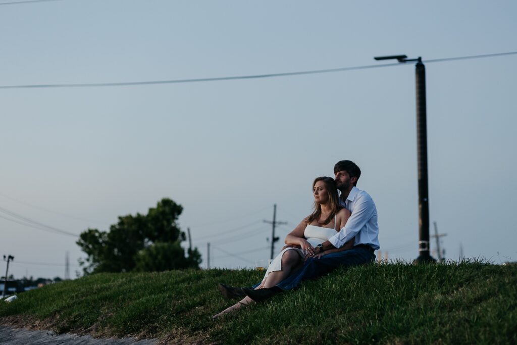 couple on levee at sunset looking at french quarter