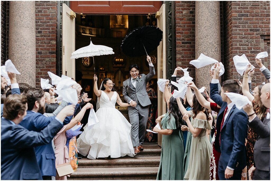 A bride and groom dance out of a New Orleans church while wedding guests wave handkerchiefs.