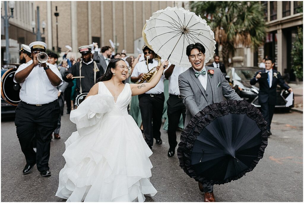 A bride and groom lead a New Orleans wedding parade down Canal Street.