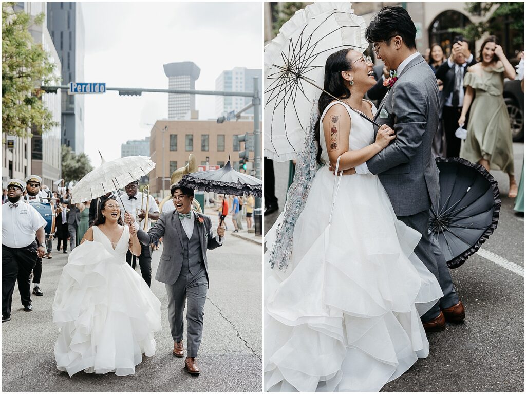 A bride carrying a New Orleans wedding umbrella kisses a groom in the street.