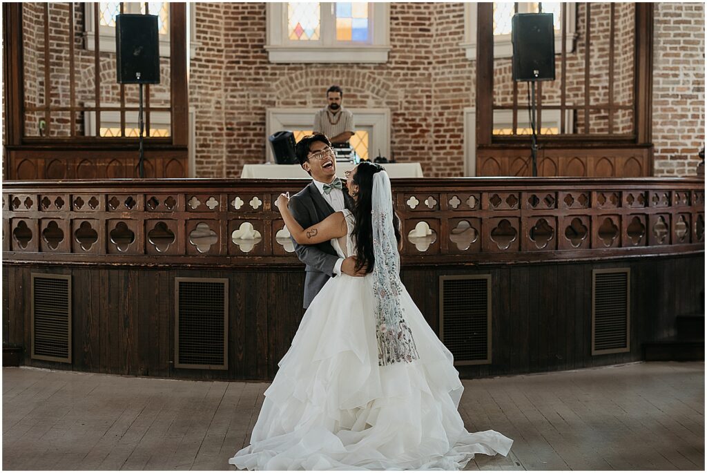A bride and groom share their first dance in the sanctuary of Felicity Church.