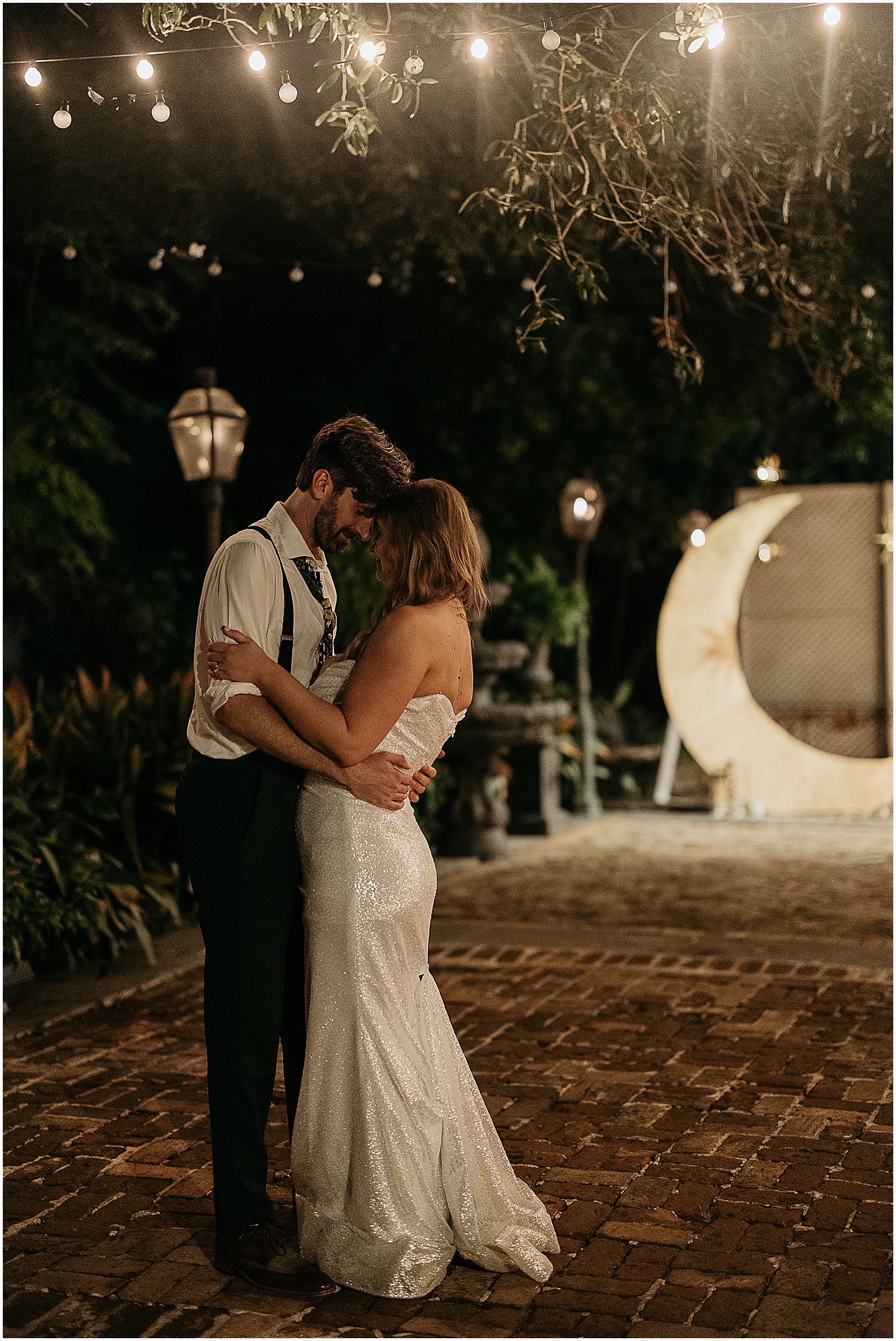 A bride and groom dance at night in the courtyard of a New Orleans wedding venue.