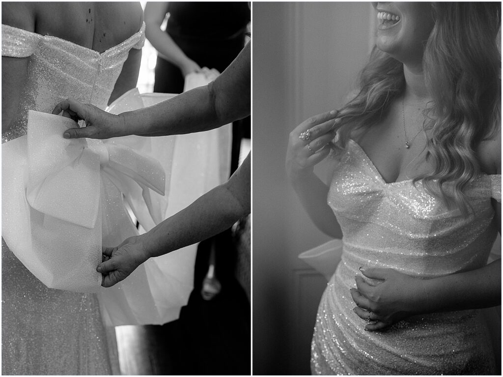 A bride's mother fluffs the bow on the back of her wedding dress.