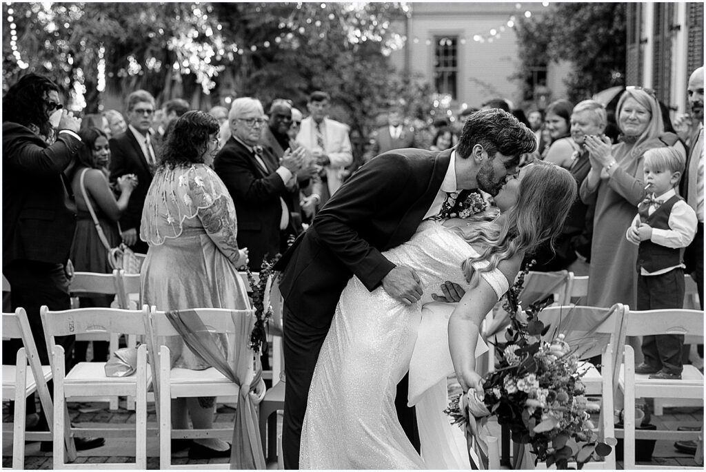 During their recessional, a groom kisses a bride.
