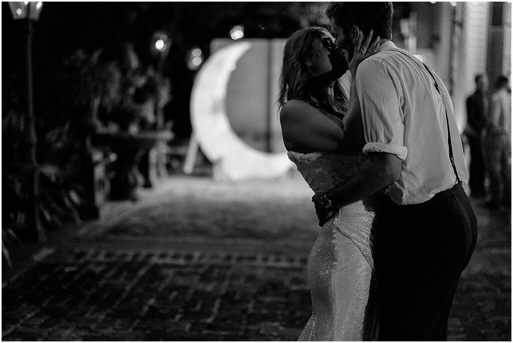 A bride and groom kiss at the end of their New Orleans wedding reception.