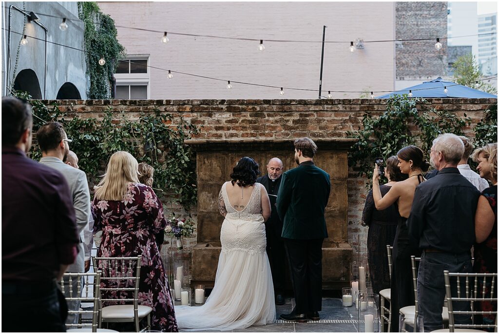 A bride and groom greet their New Orleans wedding officiant.