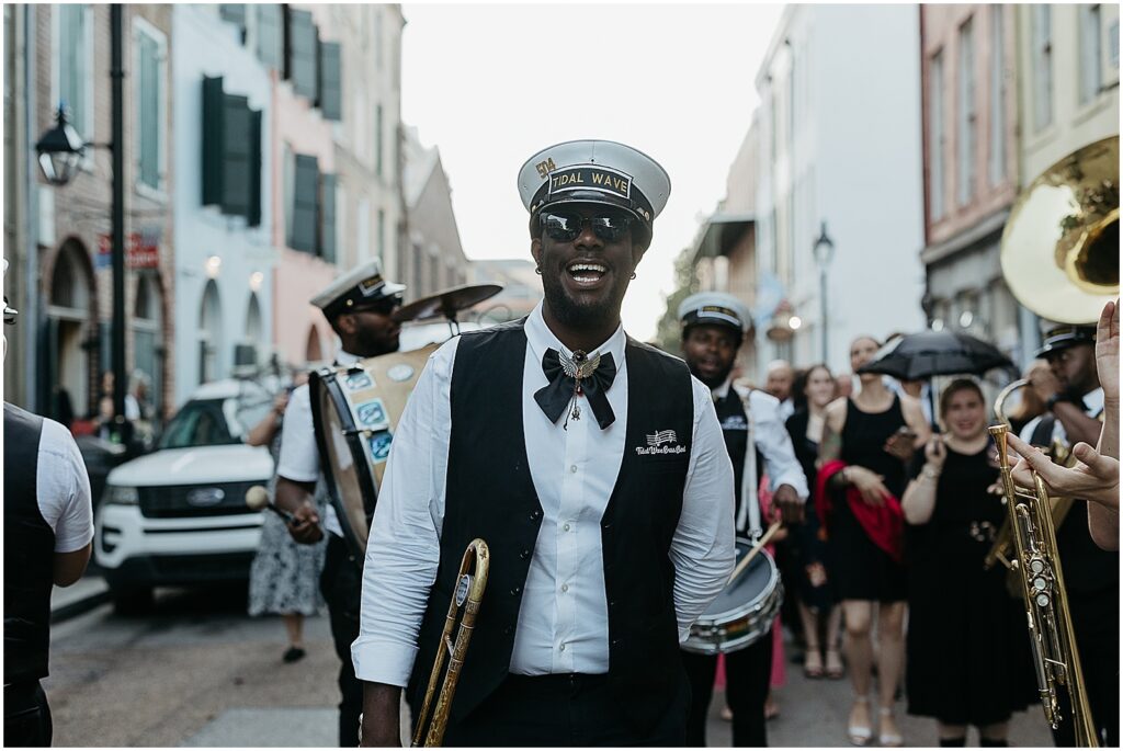 A brass band leader leads a wedding second line.