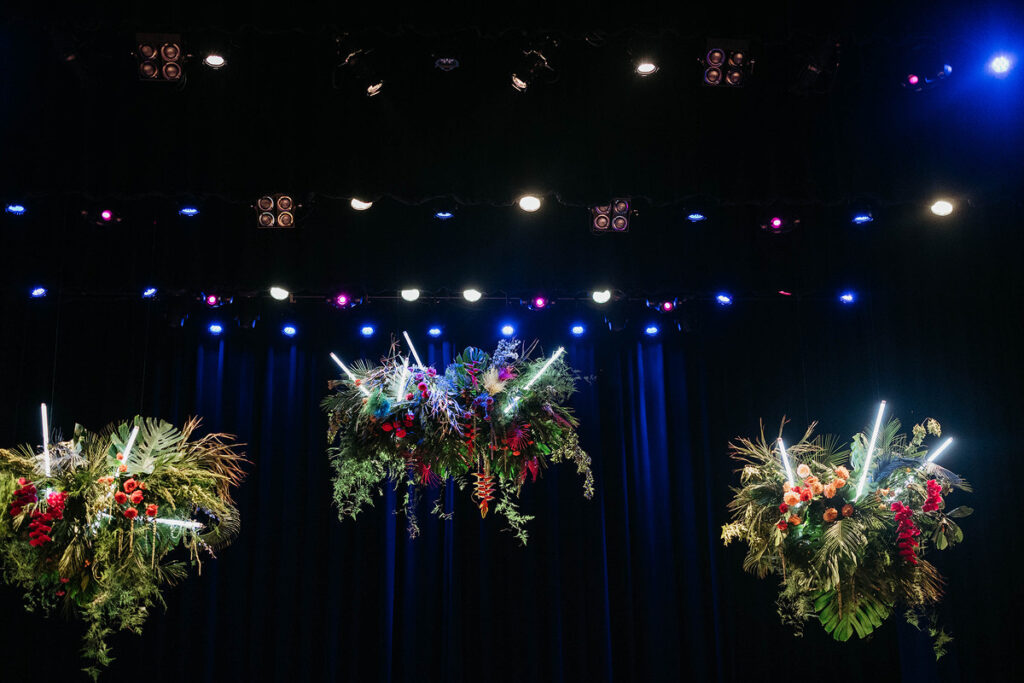 Floral arrangements with lights hanging from the ceiling 