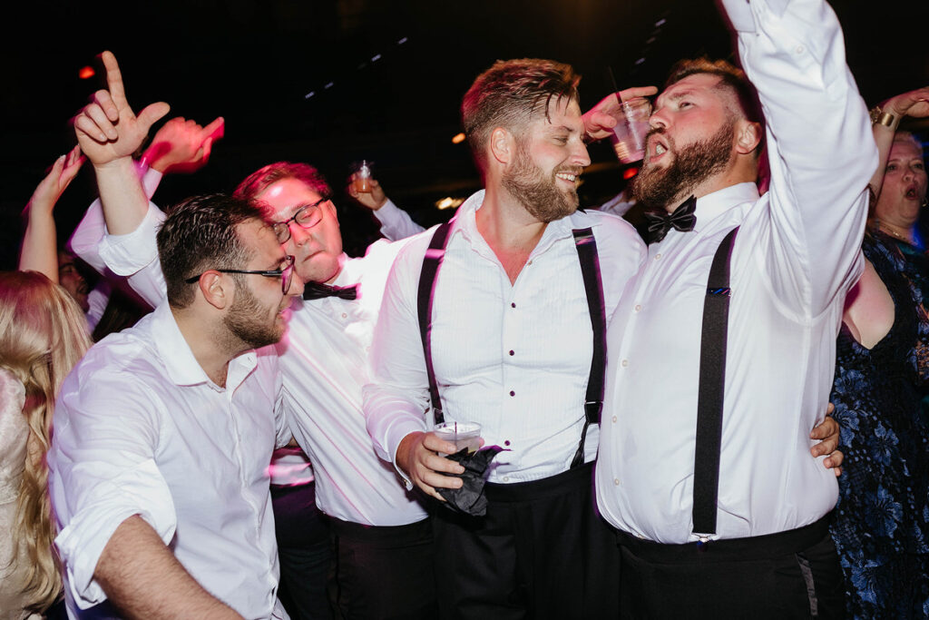 Wedding guests dancing and holding drinks
