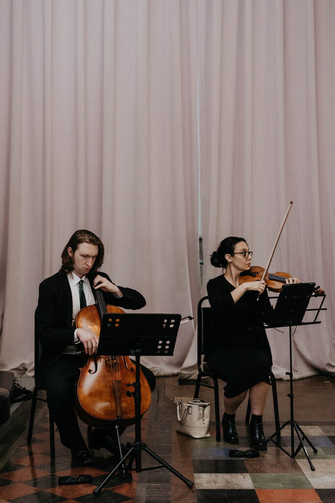 Two people playing stringed instruments 