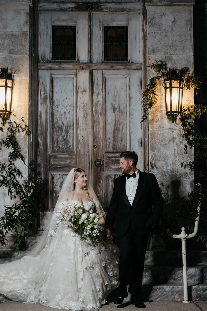 A newlywed couple smiling at each other 