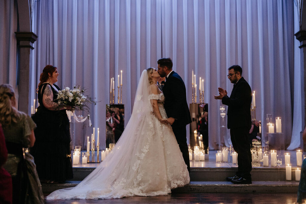 A couple during their first kiss at their wedding 