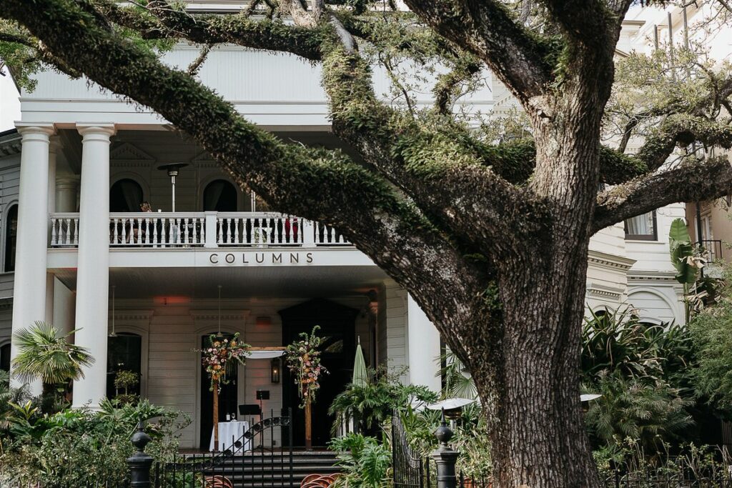 The front of the Columns wedding venue with a large tree in front 
