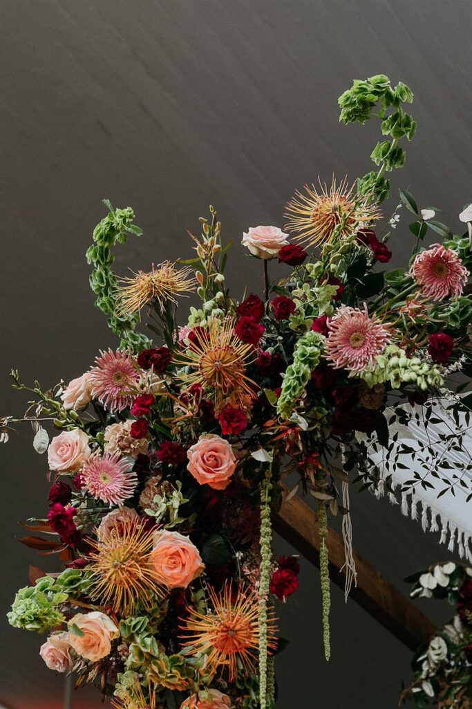 Close-up of the elaborate floral decoration on the wedding arch.
